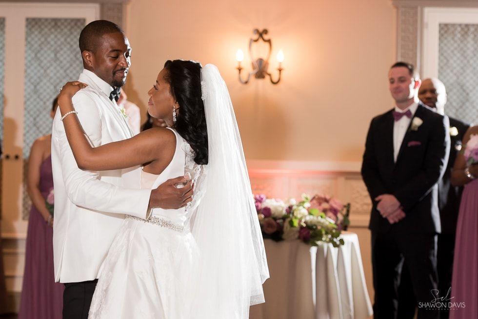 Bride and groom embrace during wedding ceremony in a warmly lit church