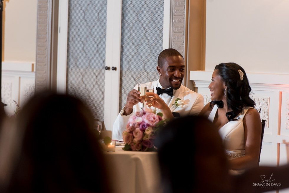 Couple smiling at a decorated table during a wedding reception