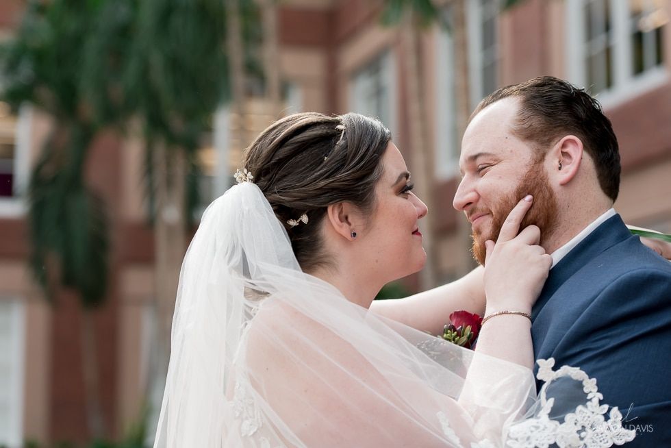 Bride and groom sharing a tender moment outdoors, smiling face-to-face in wedding attire
