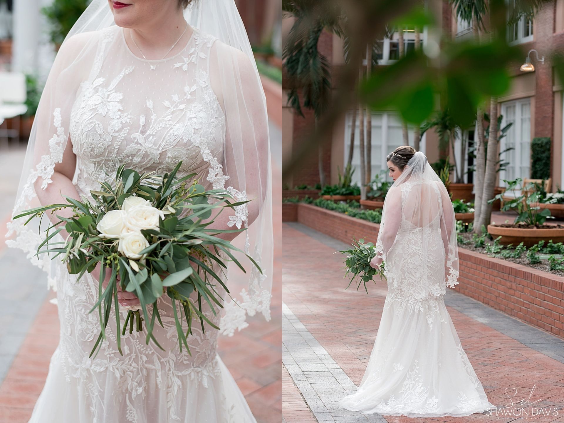 Bride in a lace wedding gown holding a white-and-green bouquet on a brick walkway.