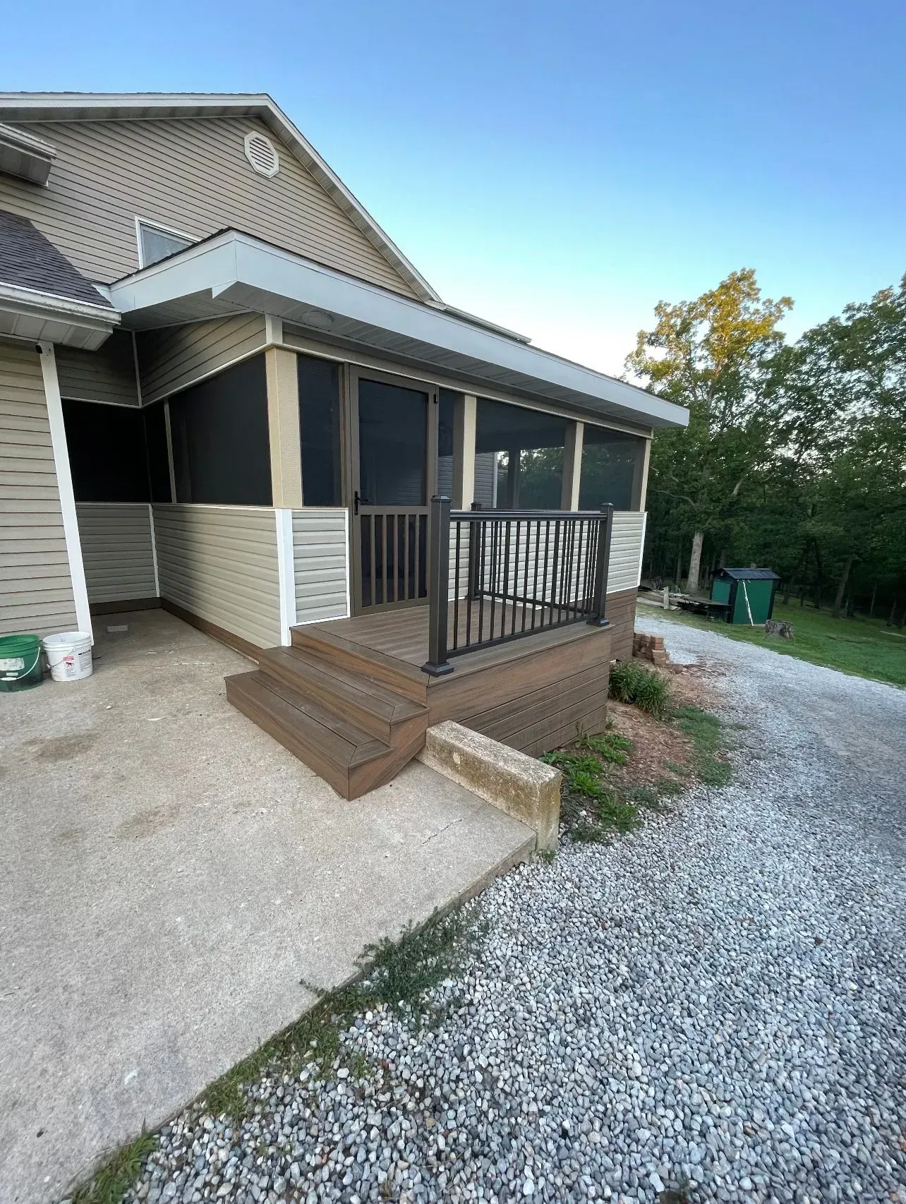 A house with a screened in porch and stairs.