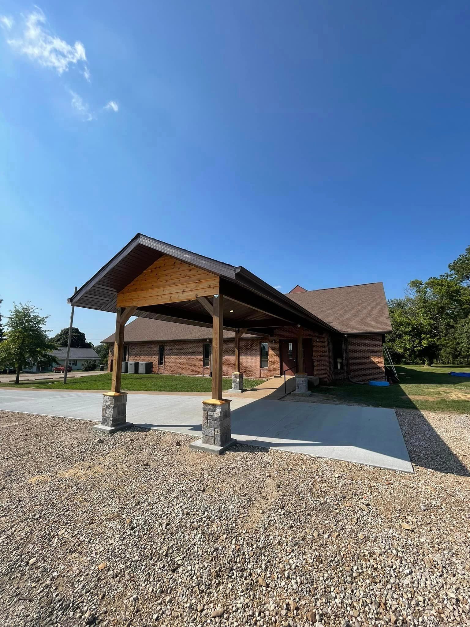 A large brick house with a carport in front of it.