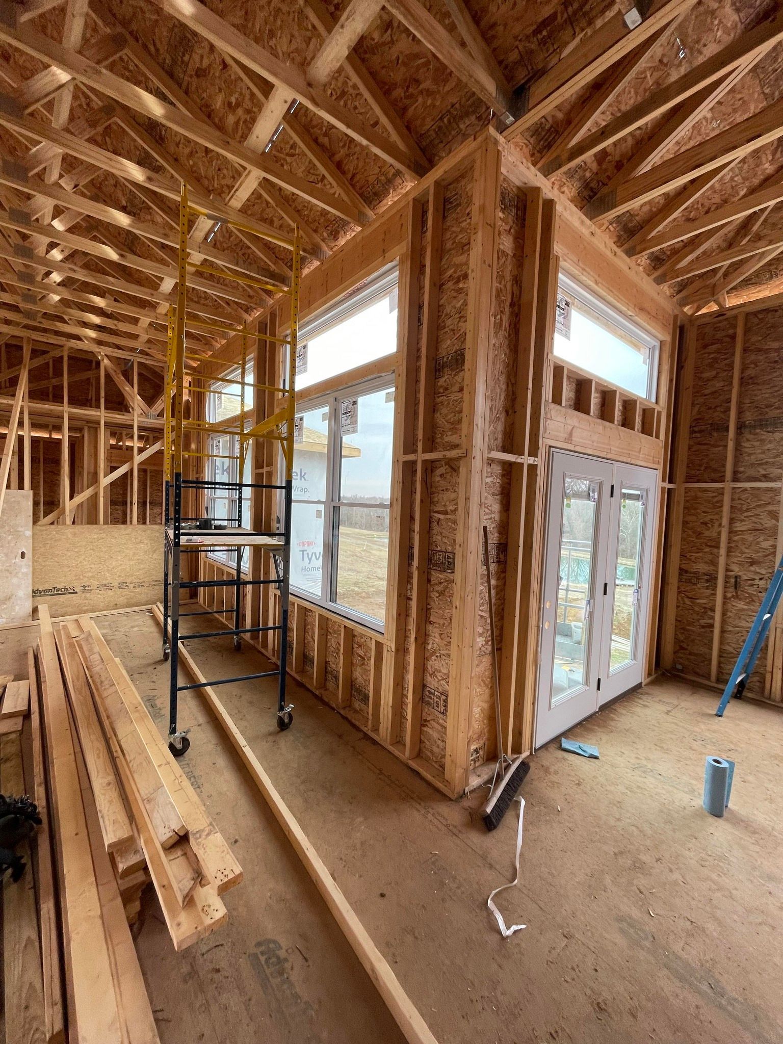 A house is being built with a lot of wood and windows.