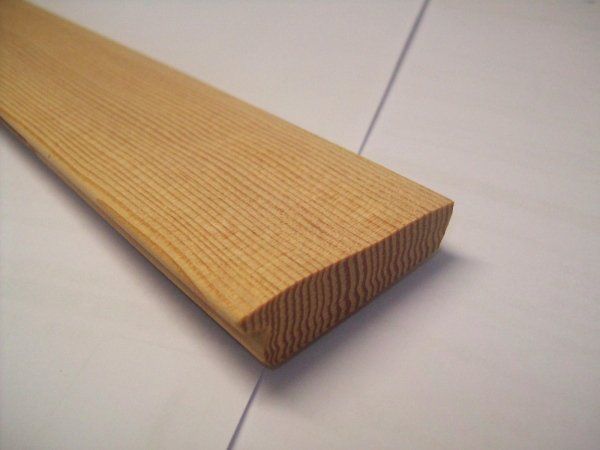 Tavola di legno con bordo arrotondato, che mostra le venature del legno visibili.