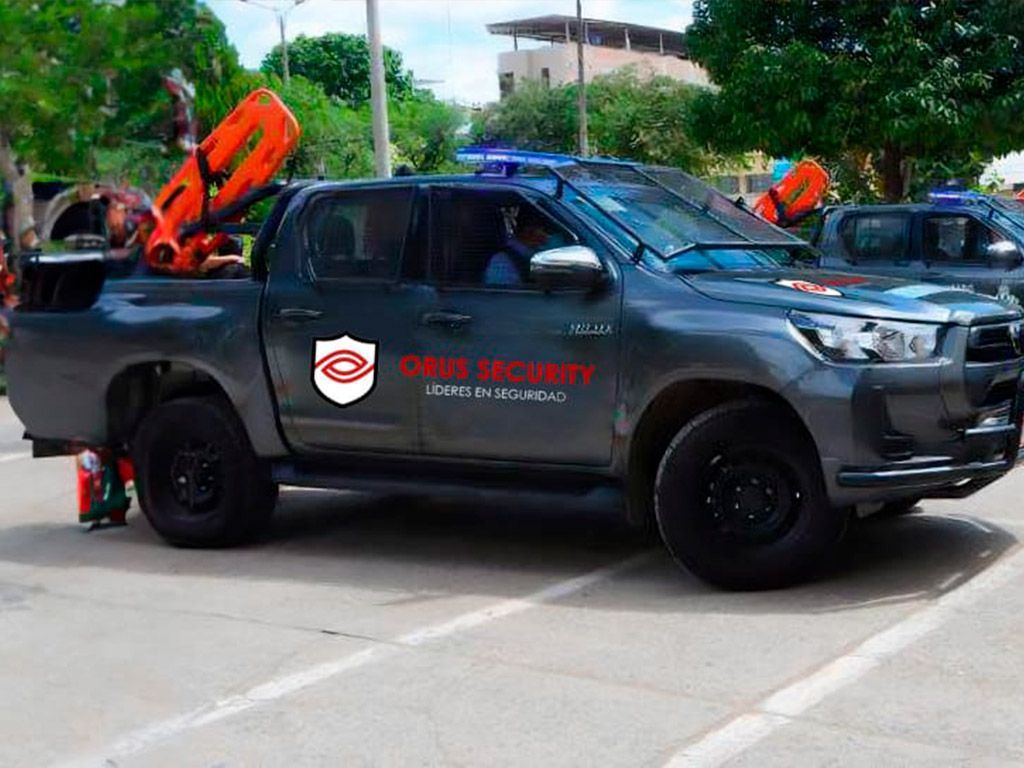 Camión de seguridad gris oscuro con equipo de emergencia; logotipo