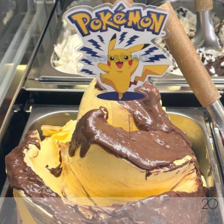 Gelato soft a tema Pikachu con glassa al cioccolato, presentato in una vetrina e sormontato da un cartello Pokémon.