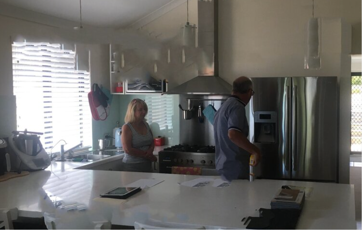 A man and a woman are standing in a kitchen