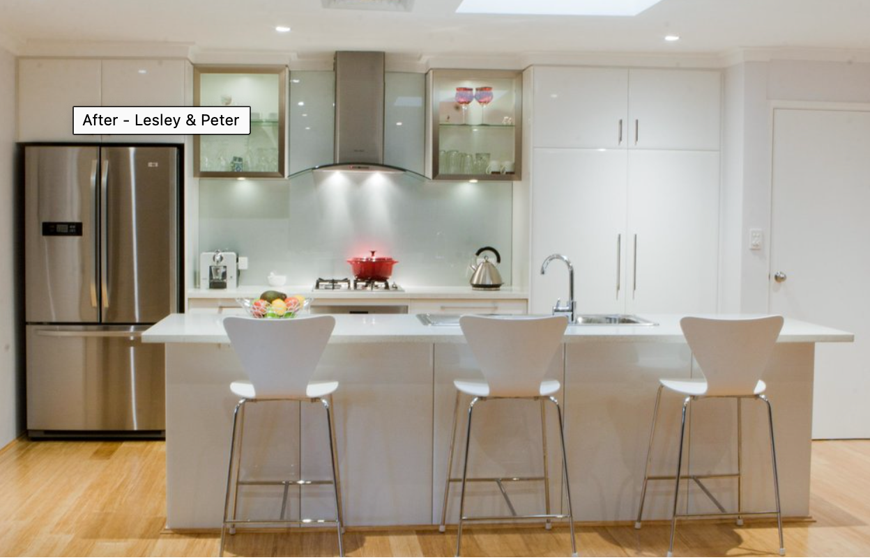 A kitchen with white cabinets and a stainless steel refrigerator