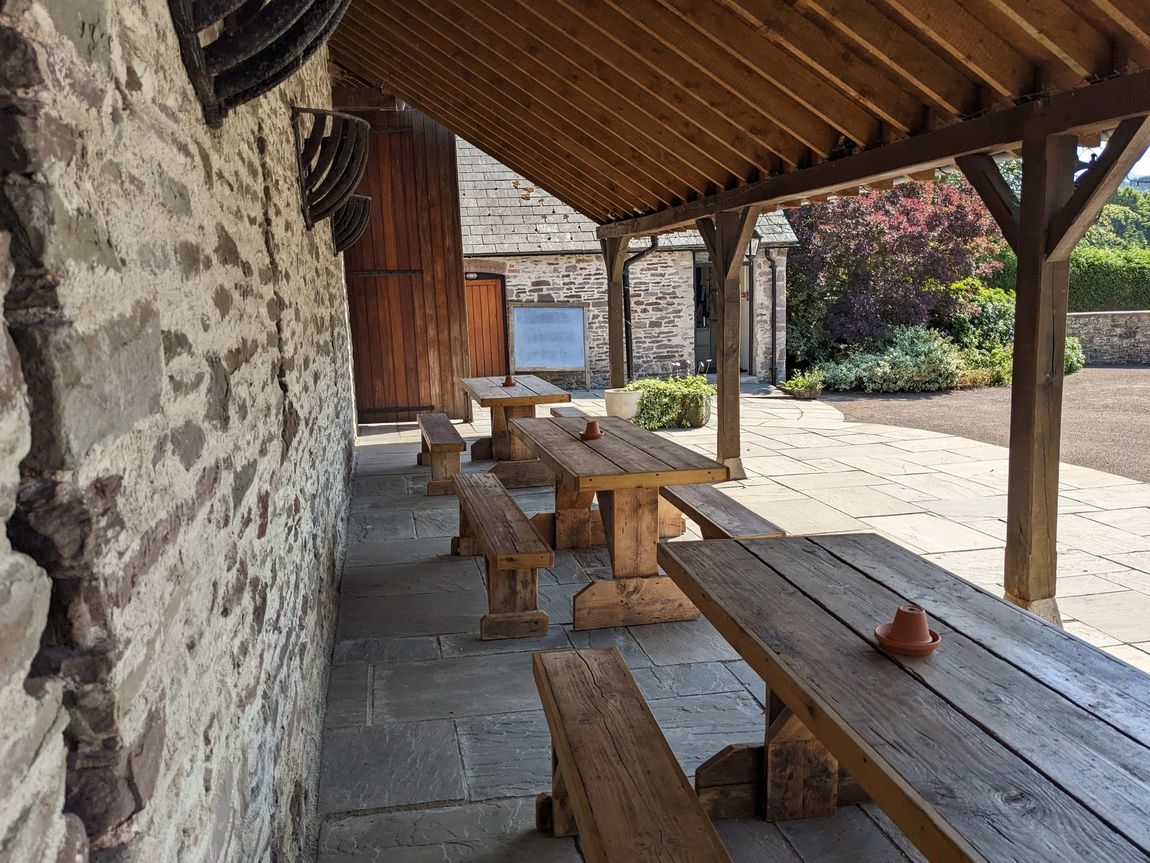 Picnic benches under the leanto outside the Barn