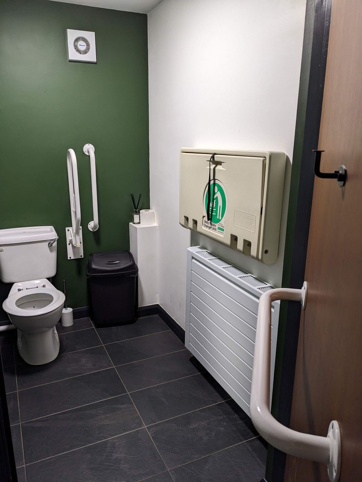 Disabled restroom with toilet,safety rail sink, and changing station.