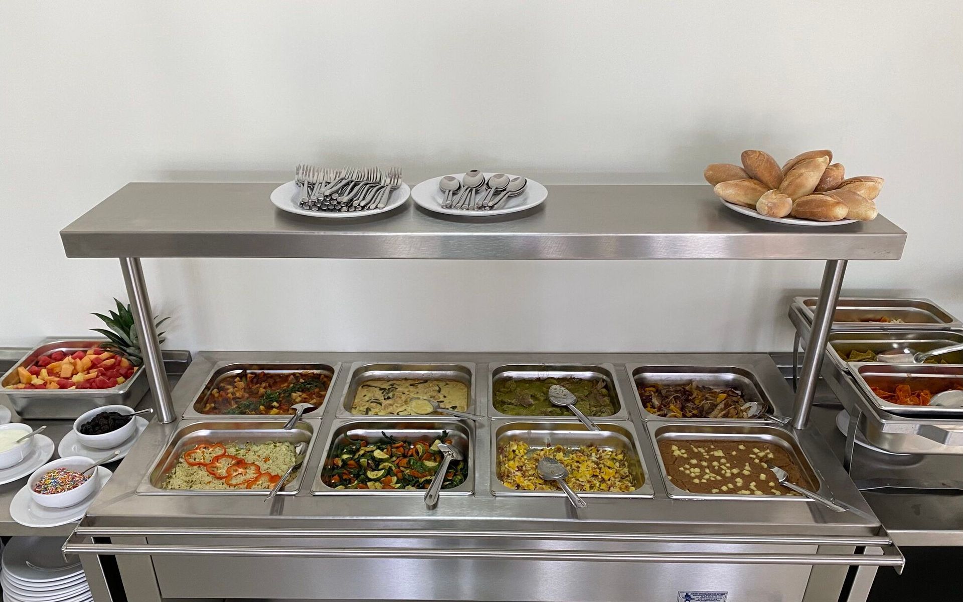 Una línea de buffet llena de muchos tipos diferentes de comida.