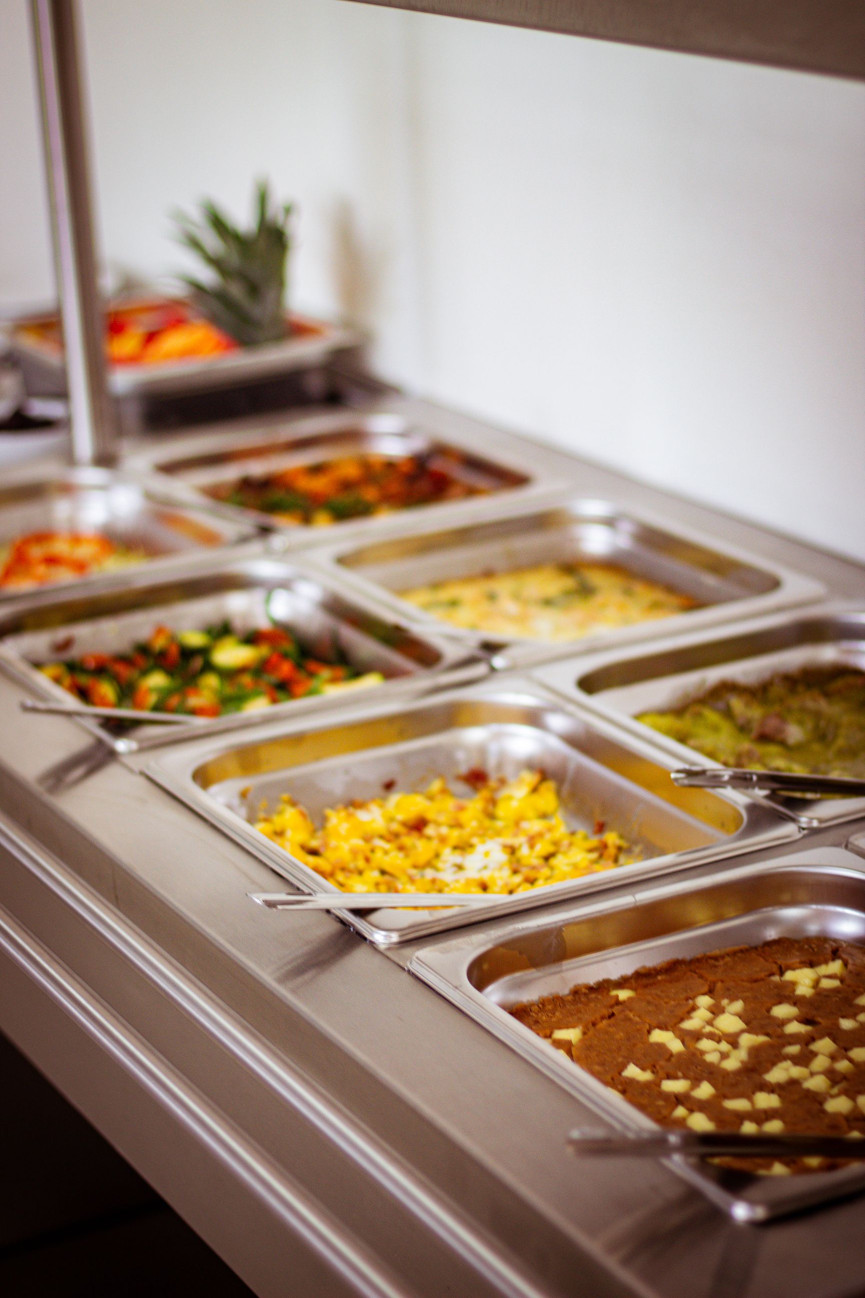Una línea de buffet llena de muchos tipos diferentes de comida.