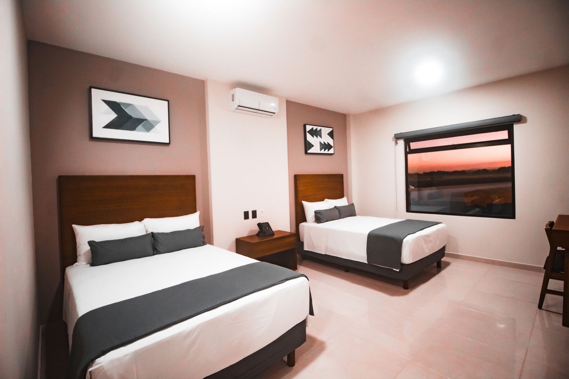 Una habitación de hotel con dos camas y una ventana.