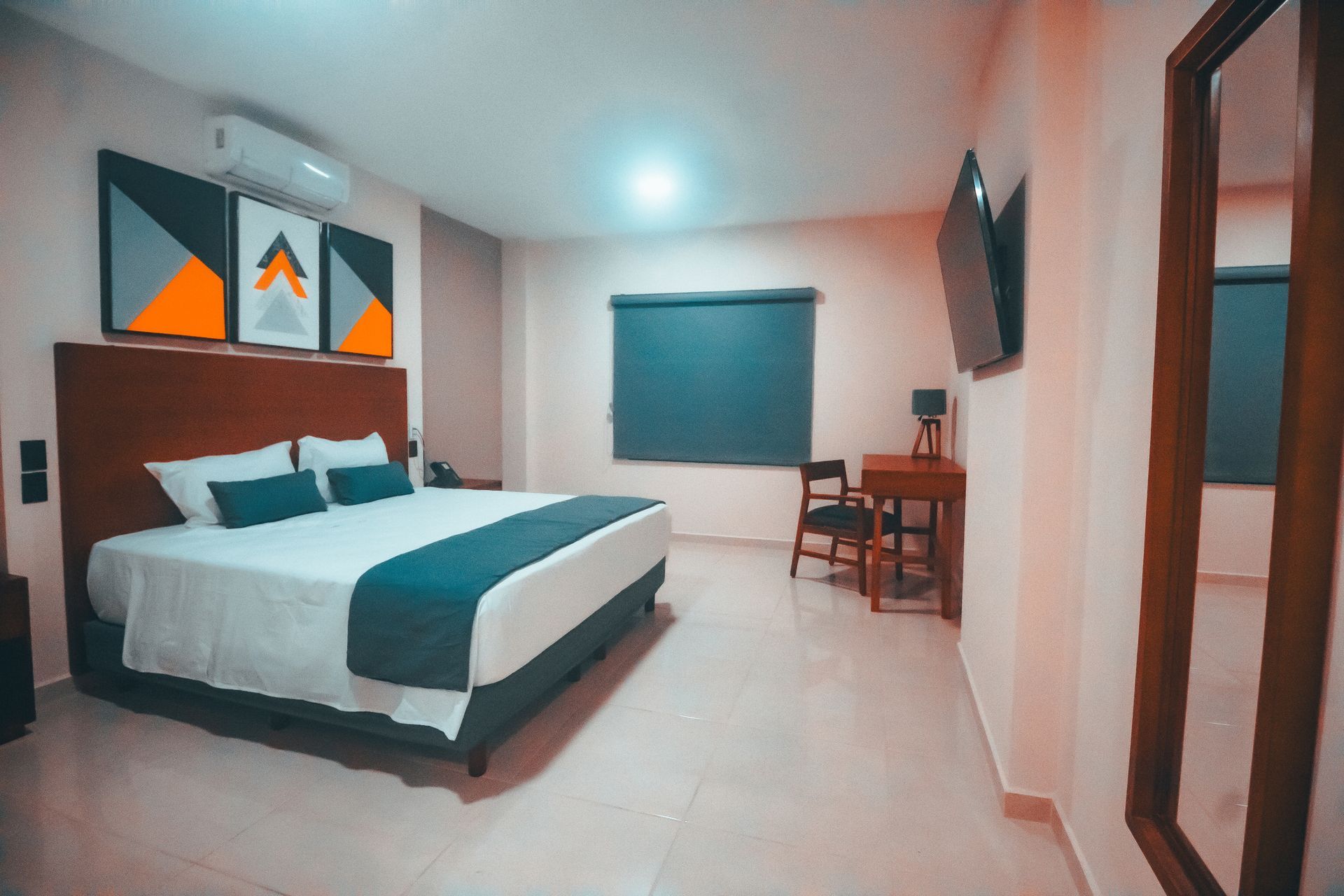 Una habitación de hotel con una cama tamaño king, mesa y sillas.