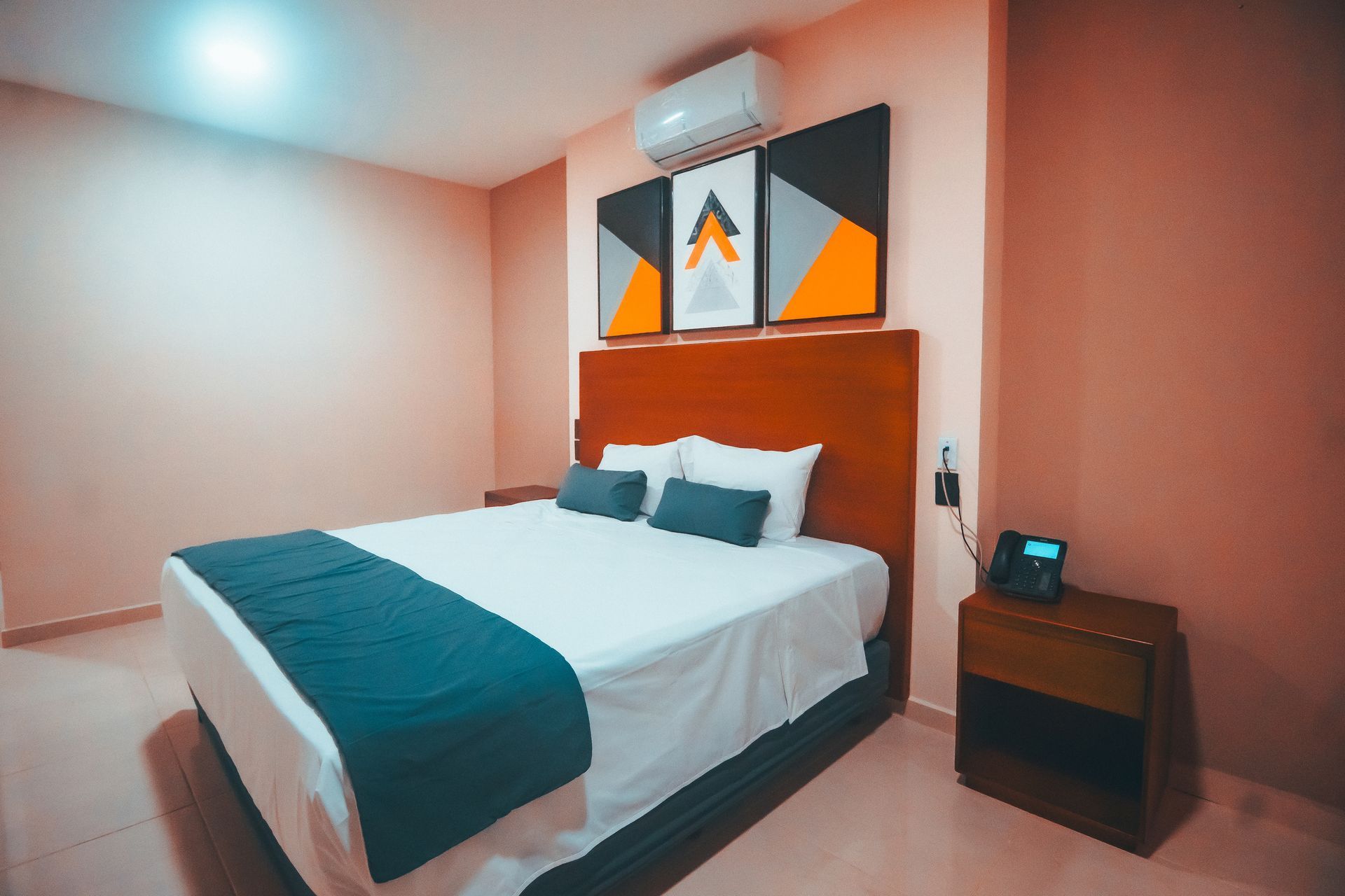 Una habitación de hotel con una cama tamaño king y una mesita de noche.