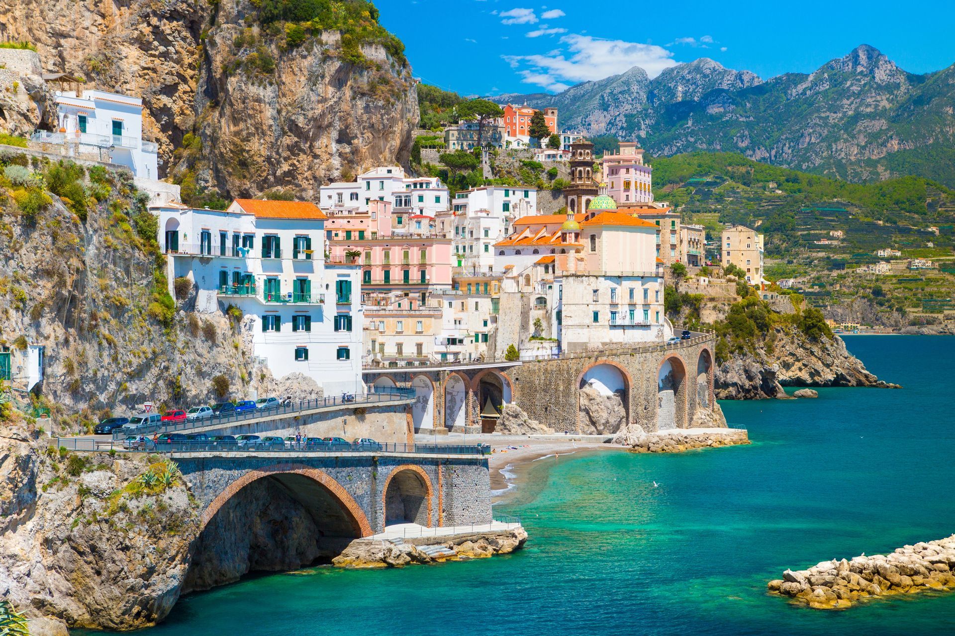 Una veduta panoramica di Atrani, sulla Costiera Amalfitana, con i suoi edifici bianchi incastonati nelle scogliere a picco sul mare blu.