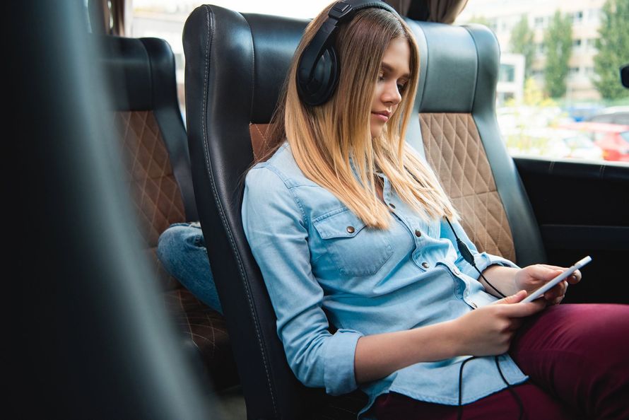 Passeggeri seduti su un autobus, visti di spalle mentre guardano verso la parte anteriore.
