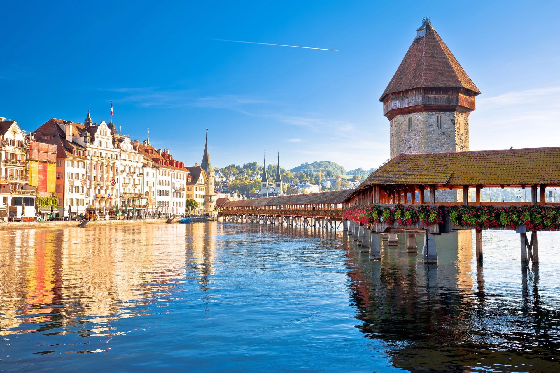 Il Ponte della Cappella e la torre Wasserturm si ergono sul fiume Reuss a Lucerna, in Svizzera, accanto a edifici storici.