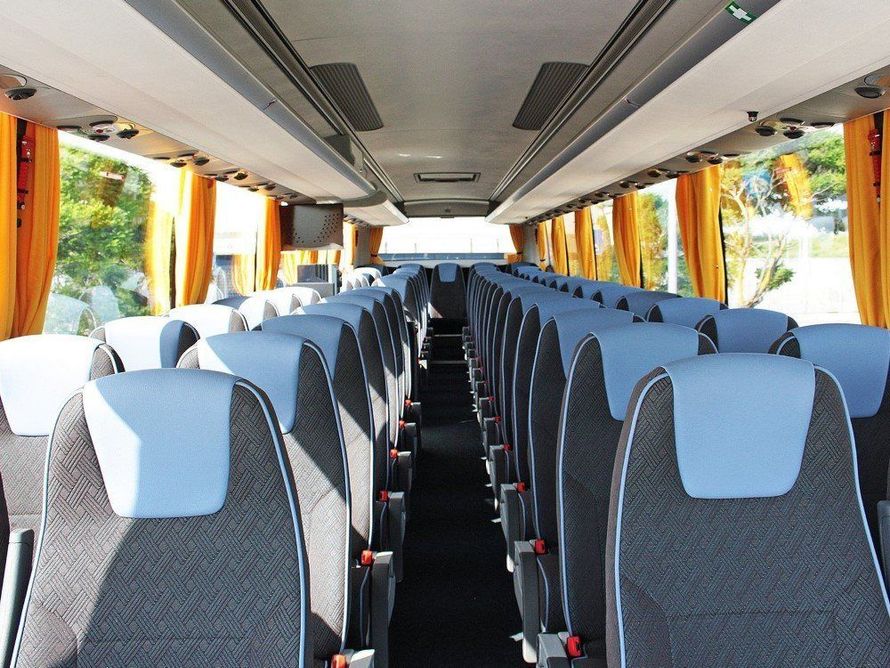 Passeggeri seduti su un autobus, visti di spalle mentre guardano verso la parte anteriore.