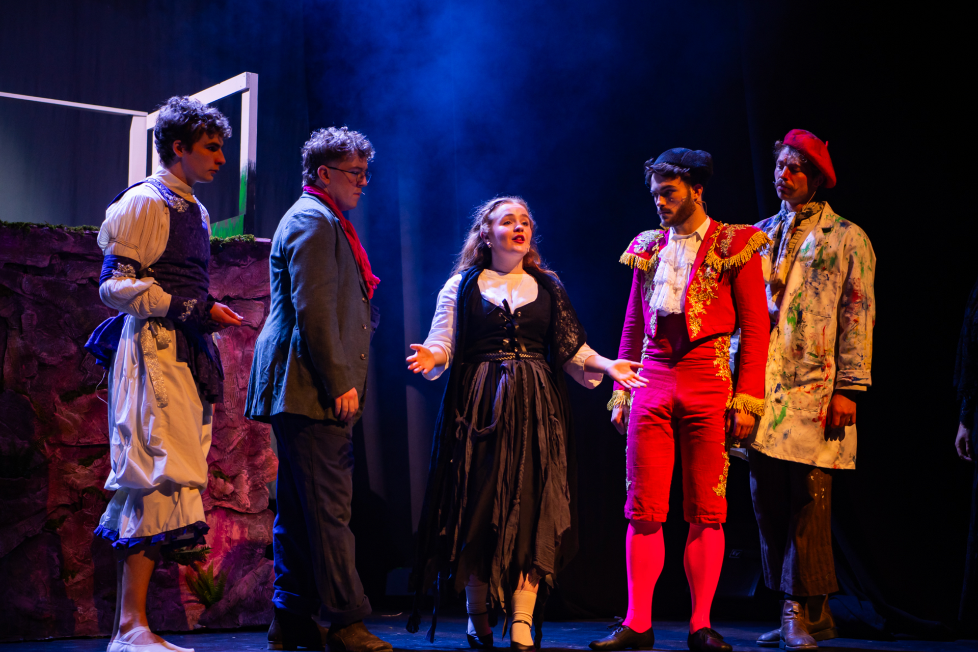A group of people are standing on a stage talking to each other.