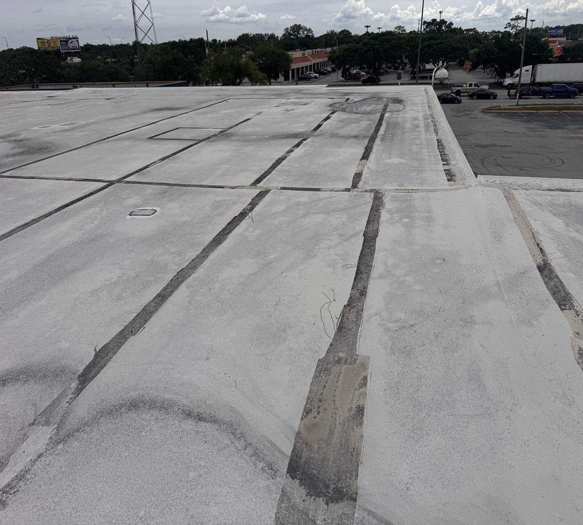 Concrete rooftop or parking deck with expansion joints under a cloudy sky