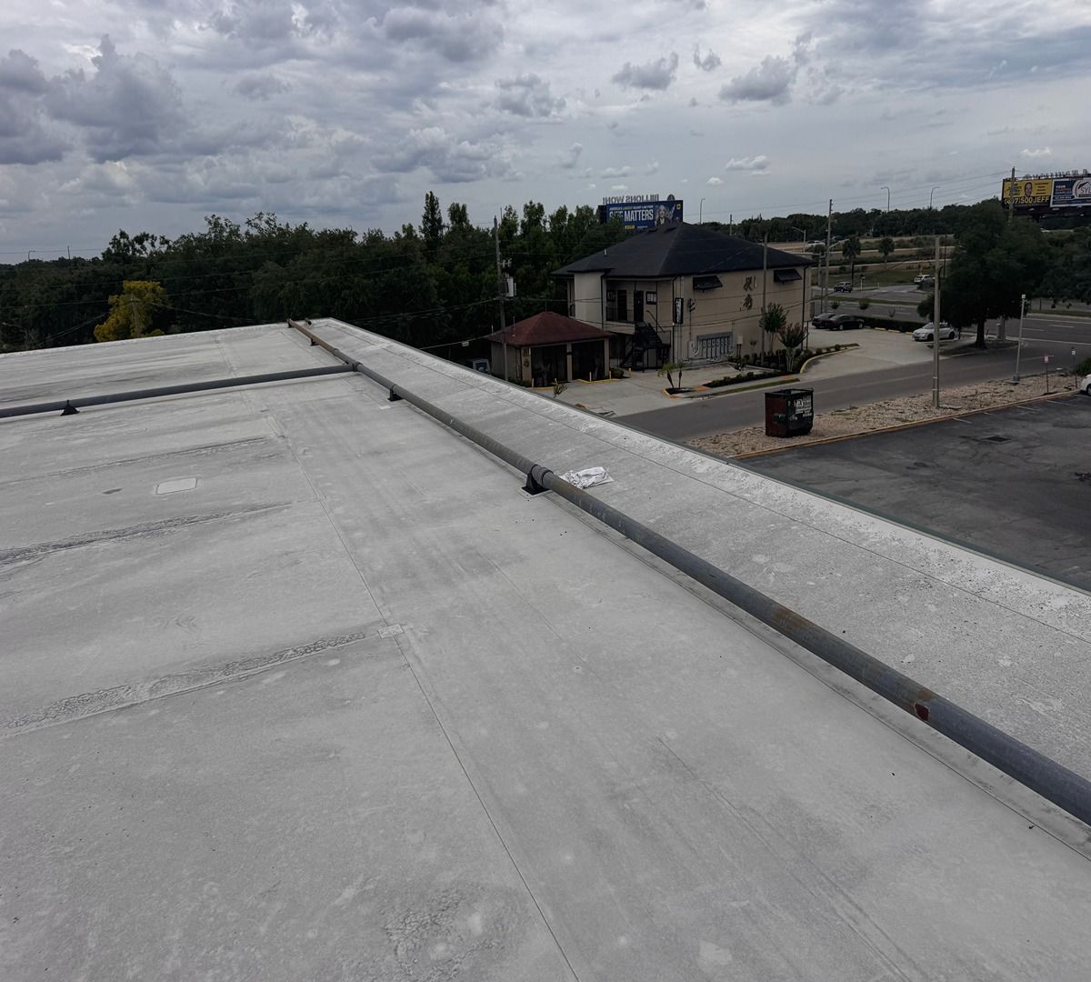 Rooftop view over a parking lot and buildings under cloudy skies