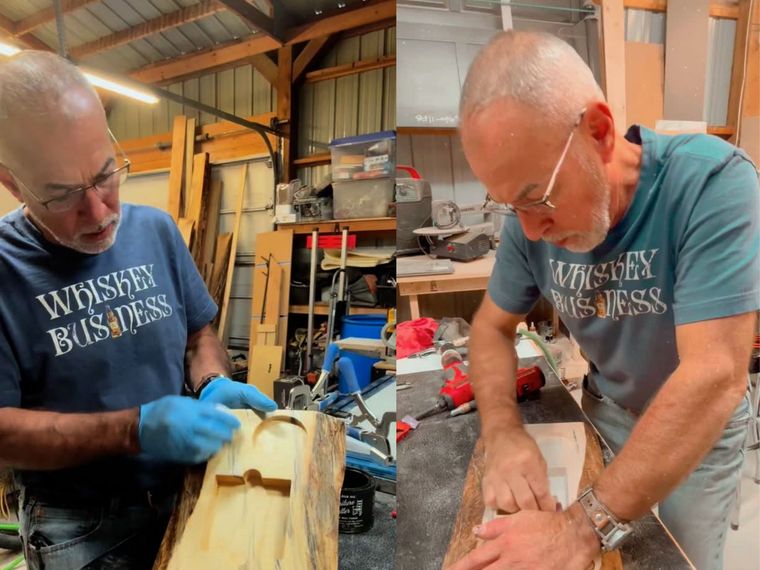 Two men in a workshop sanding a wooden board, one wearing blue gloves.