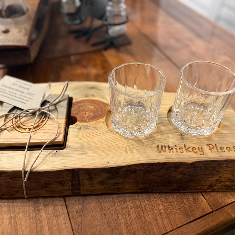 Rustic wooden tray with two empty whiskey glasses, twine, and a small note on a table