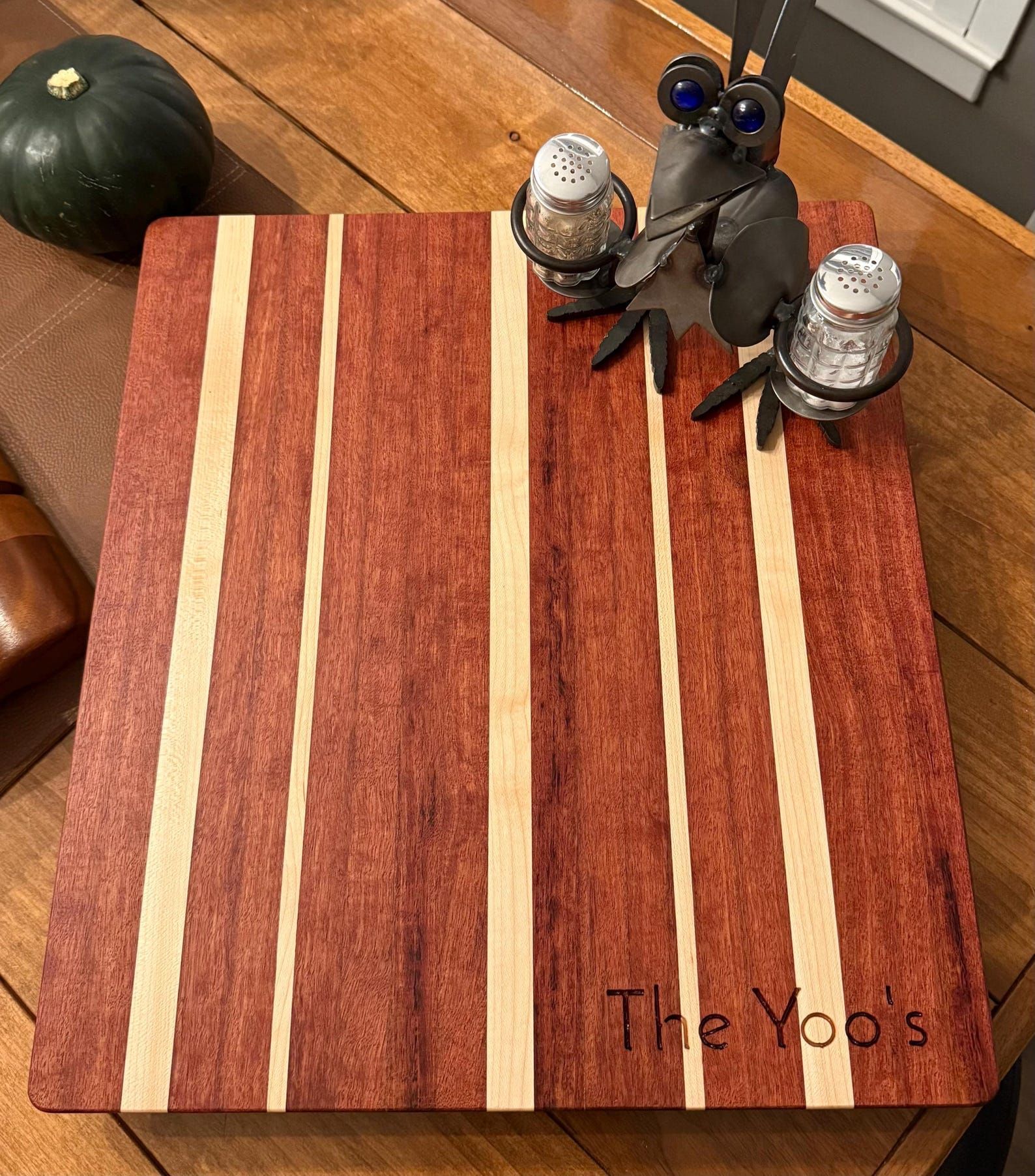Two toy birds with silver hats on a striped red mat on a wooden floor