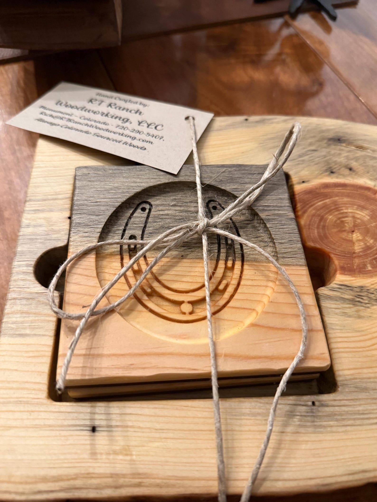 Coiled wire puzzle on a wooden base with a small metal tag, shown on a table.