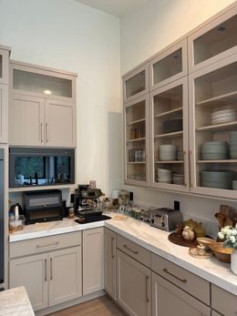 Spacious kitchen with oak cabinets, black appliances, and a central island under warm ceiling lights