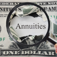 Magnifying glass over the word “Annuities” on a U.S. dollar bill background