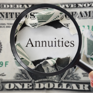 Magnifying glass over the word “Annuities” on a U.S. dollar bill background