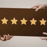 Hands holding a brown sign with five gold stars, symbolizing a 5-star rating