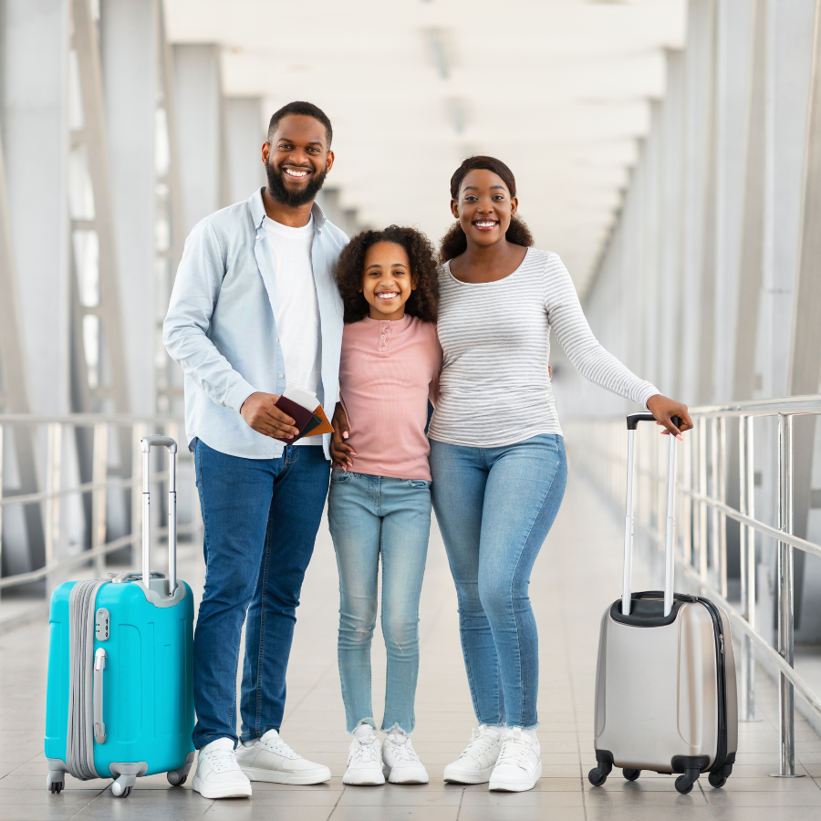 Smiling family with luggage walking through an airport terminal