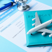 Toy airplane on a passport and travel insurance documents with a stethoscope on a blue background