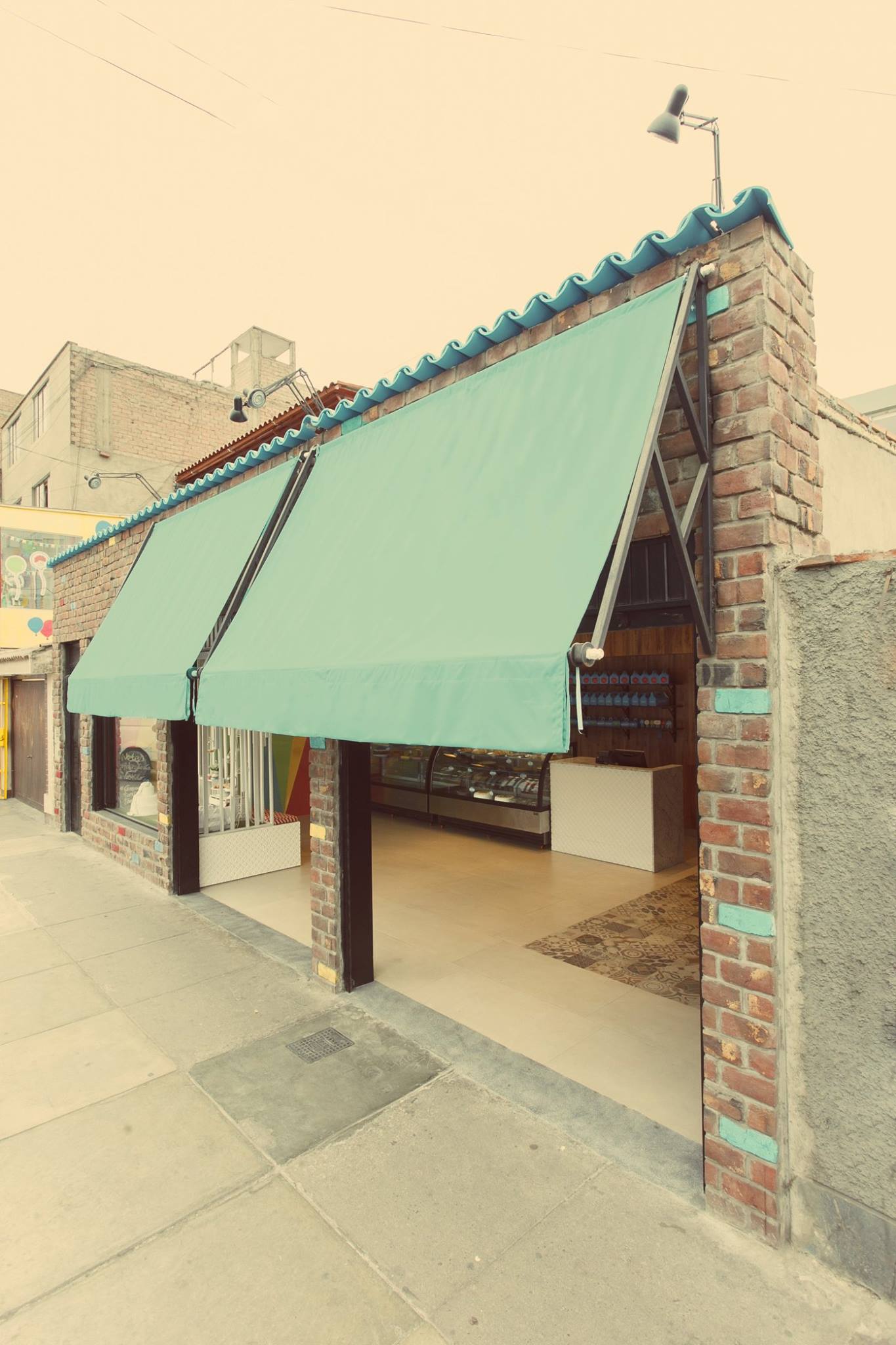 Un edificio de ladrillo con un toldo verde al costado.