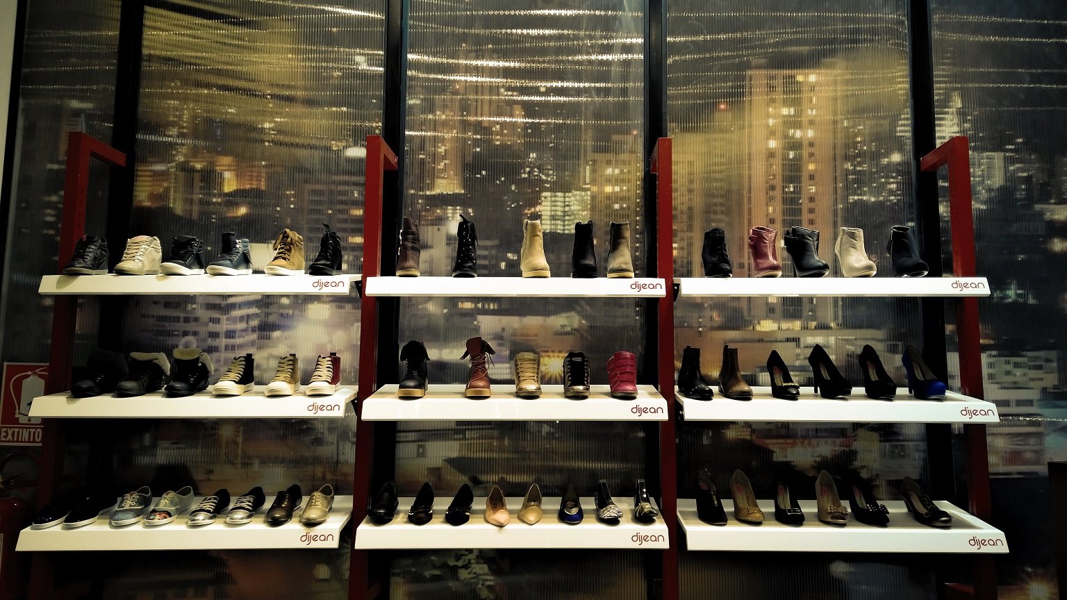 Una fila de estantes llenos de zapatos en una tienda.