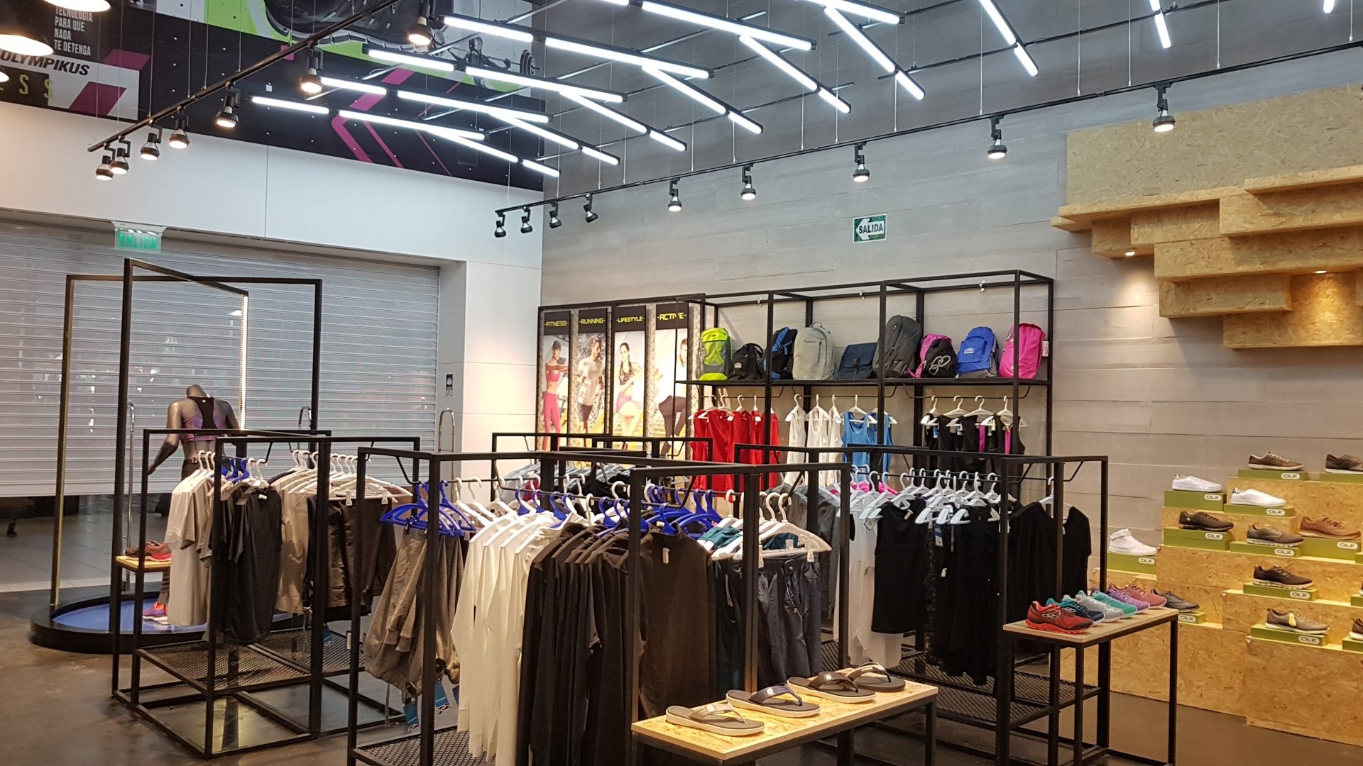 Una tienda de ropa con mucha ropa colgada en percheros.