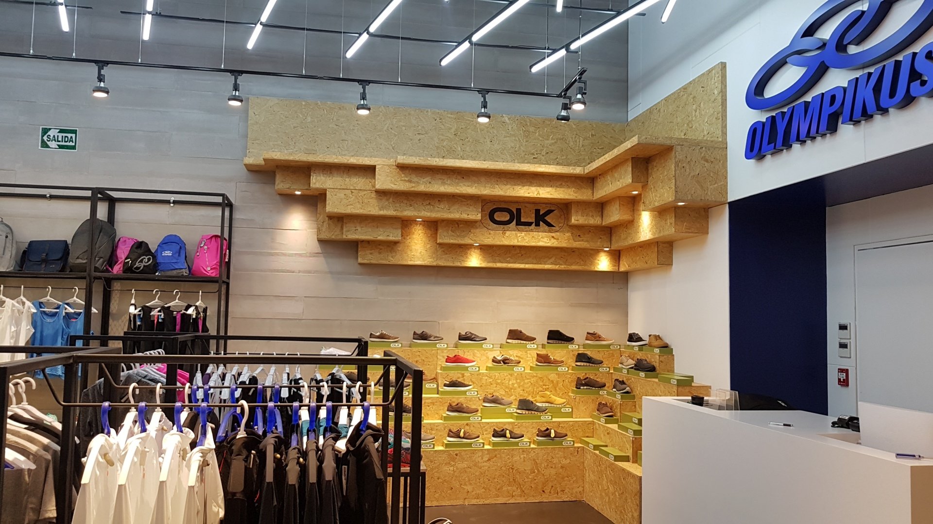 Una tienda con ropa colgada en perchas y un cartel que dice olk