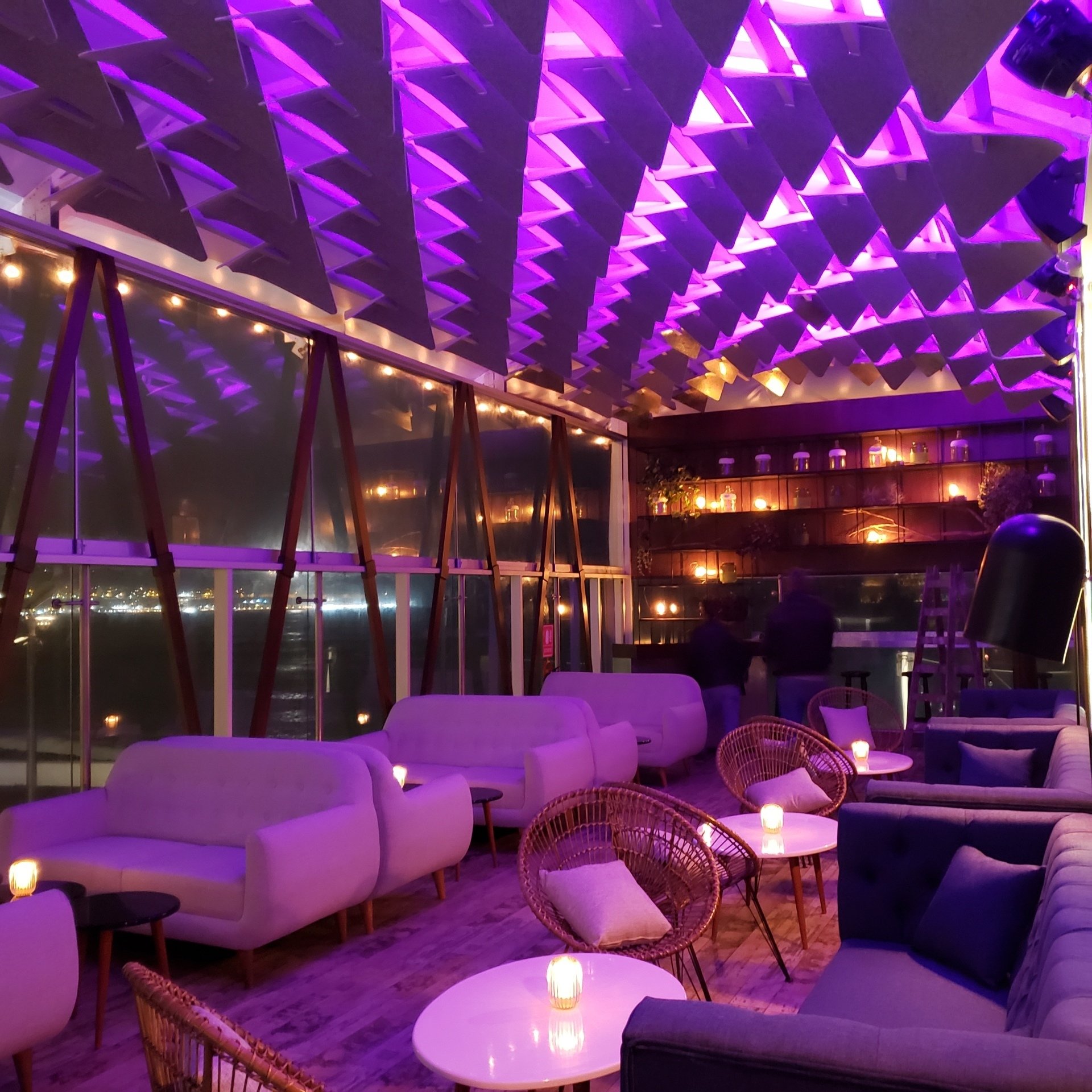 Una habitación grande con luces moradas en el techo.