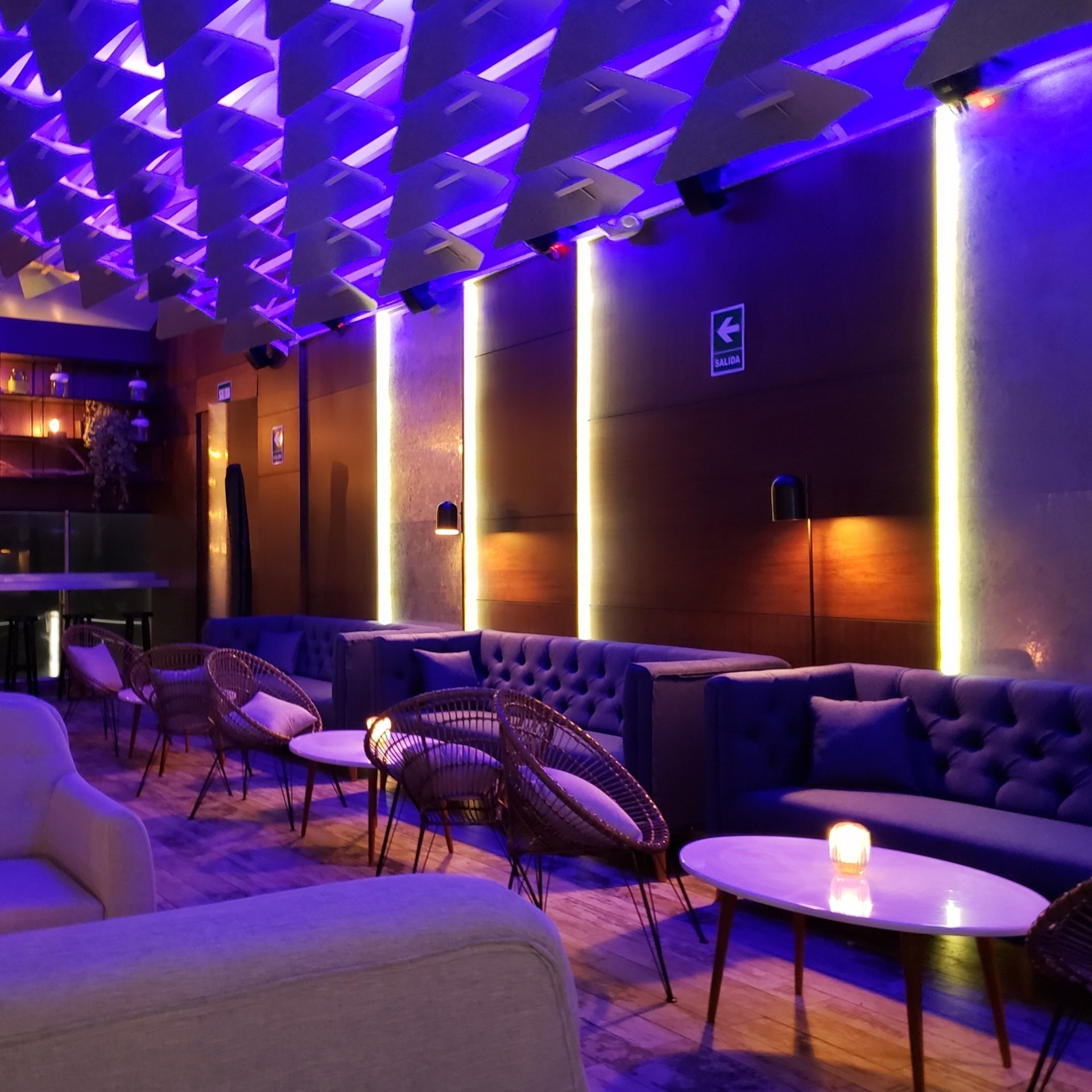 Una habitación con luces violetas y un cartel que dice salida