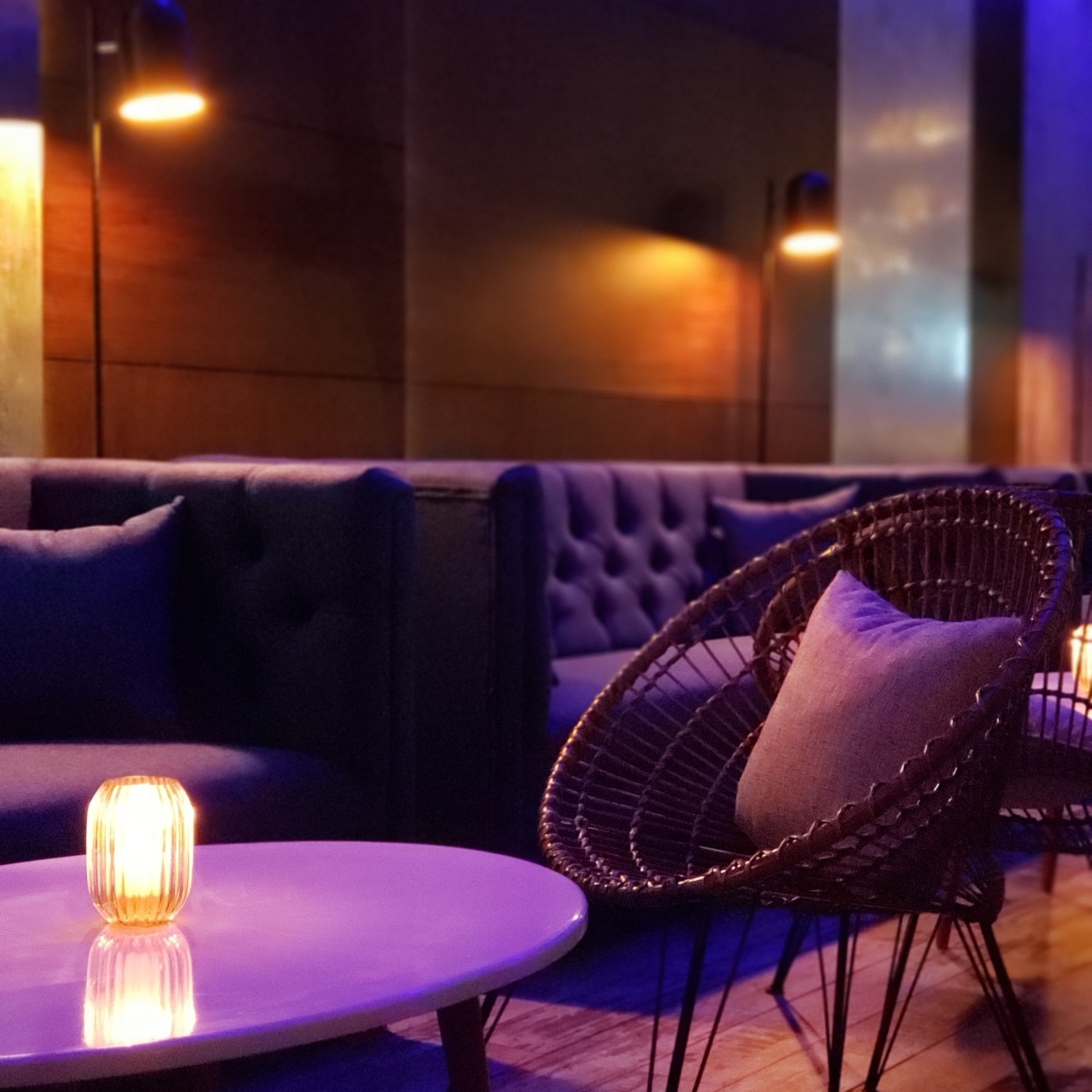 Una mesa morada con una vela encima en una habitación oscura.