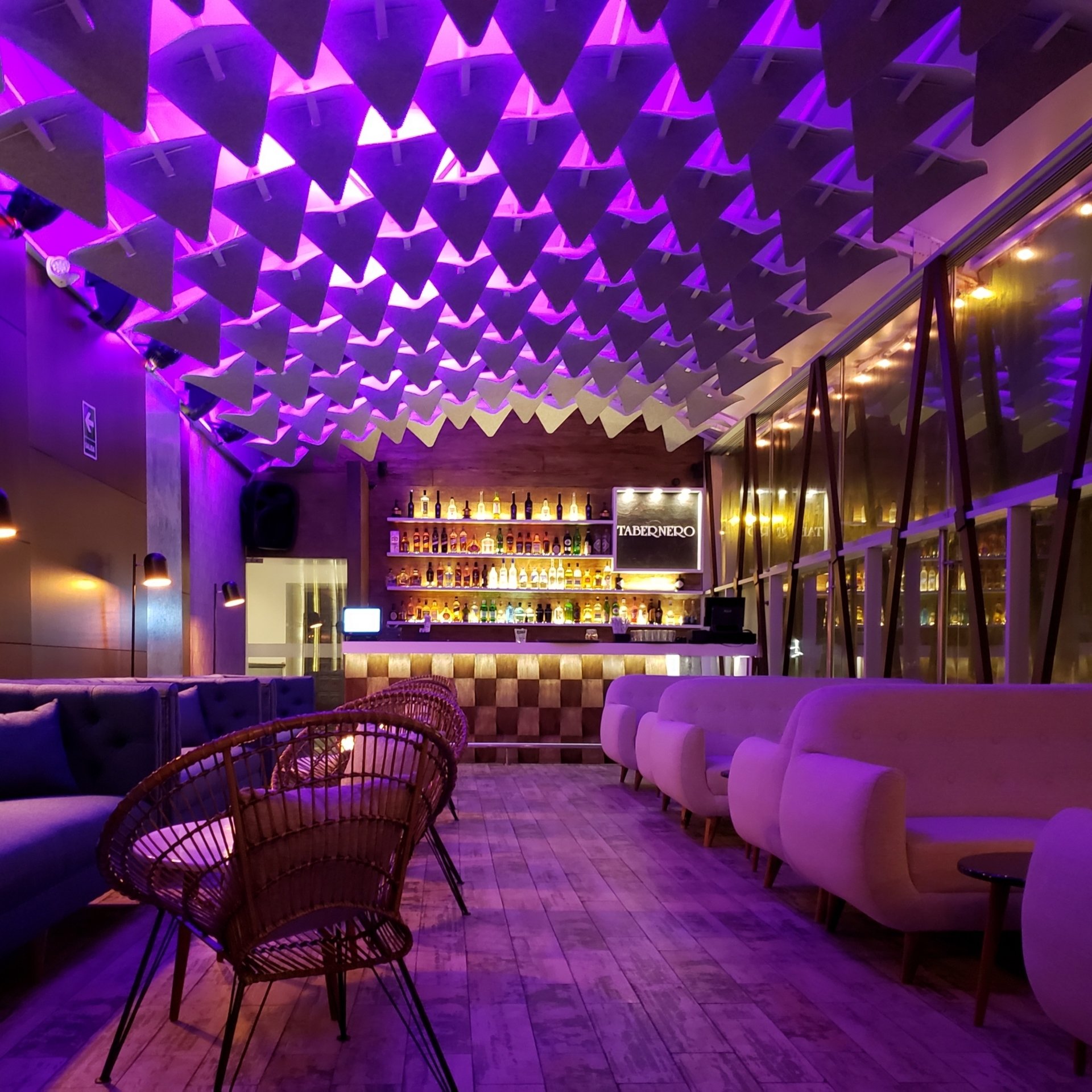 Un restaurante con luces moradas colgando del techo.