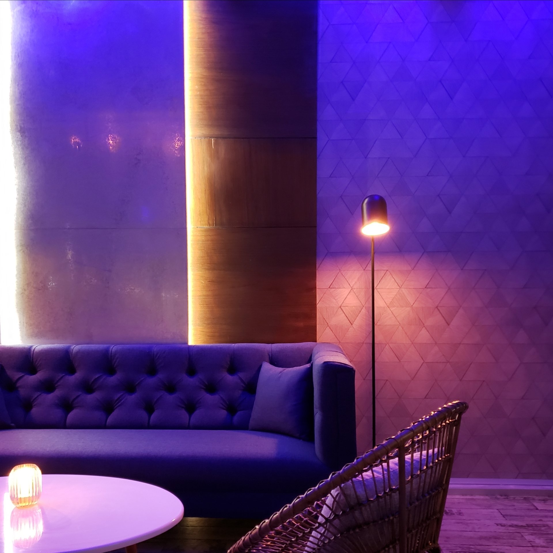 Una sala de estar con un sofá y sillas de color morado.