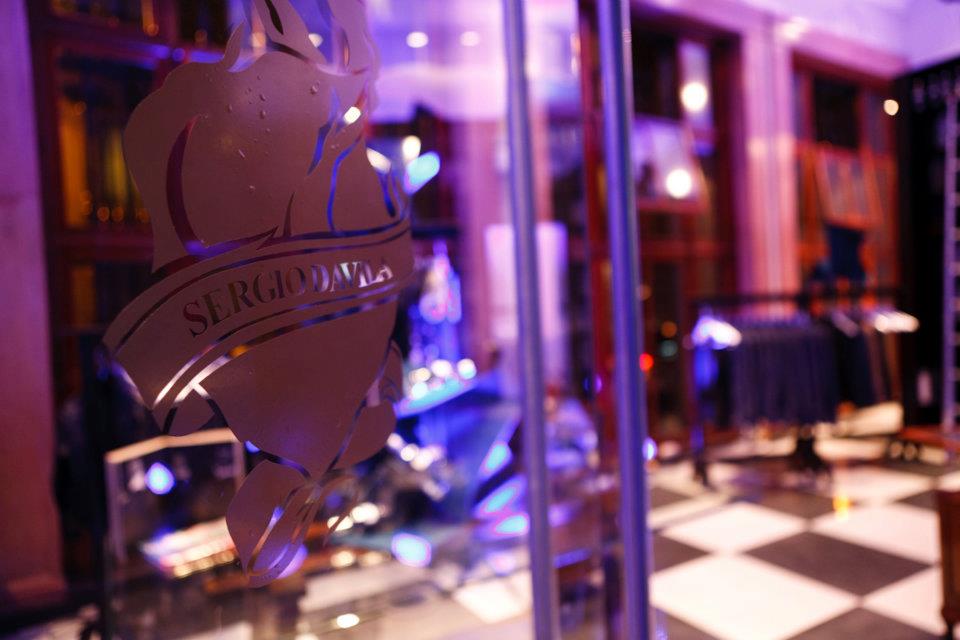 Una luz violeta brilla sobre una puerta de vidrio en una habitación con piso cuadriculado.