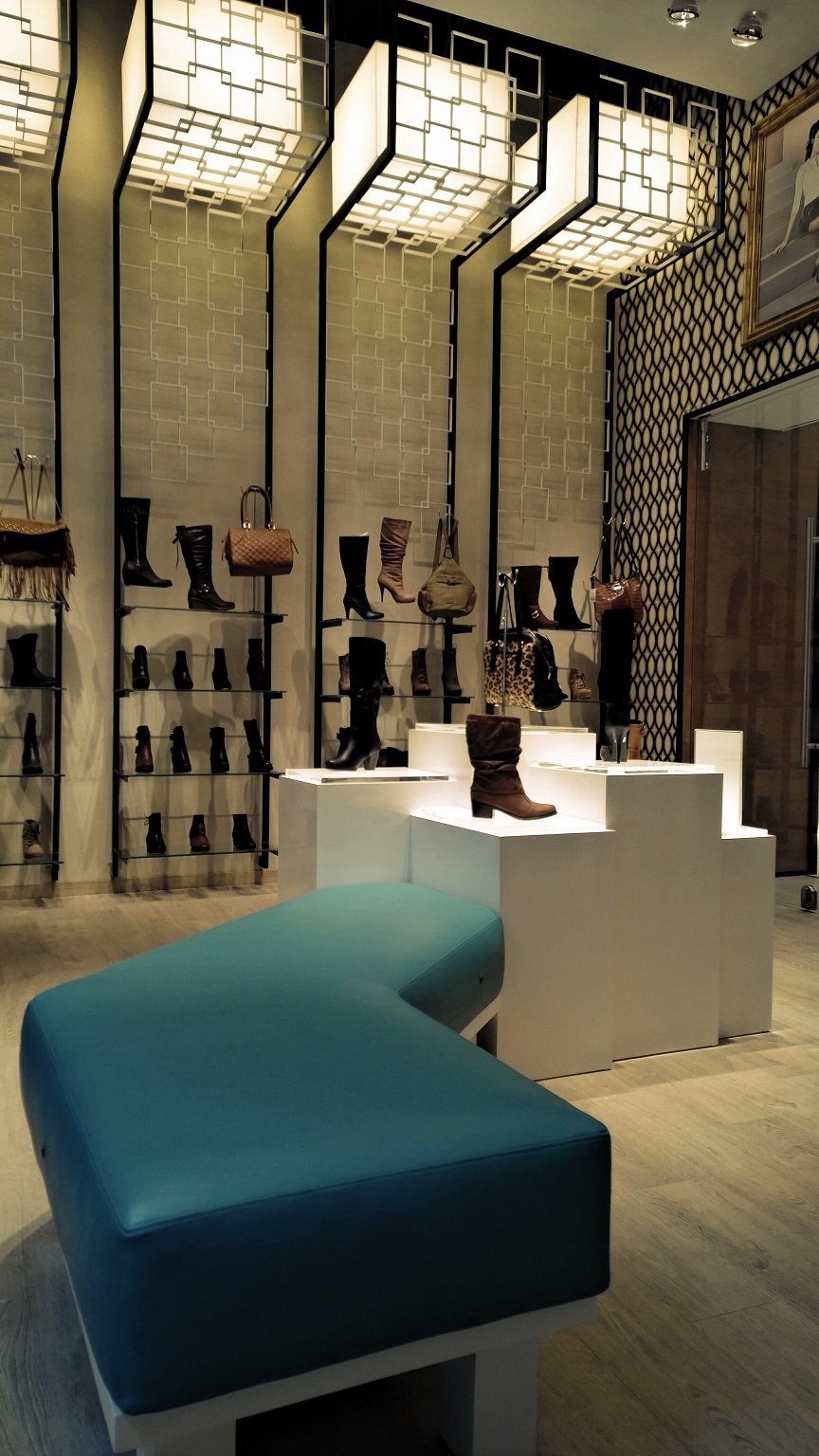 Una zapatería con un banco azul en el medio.