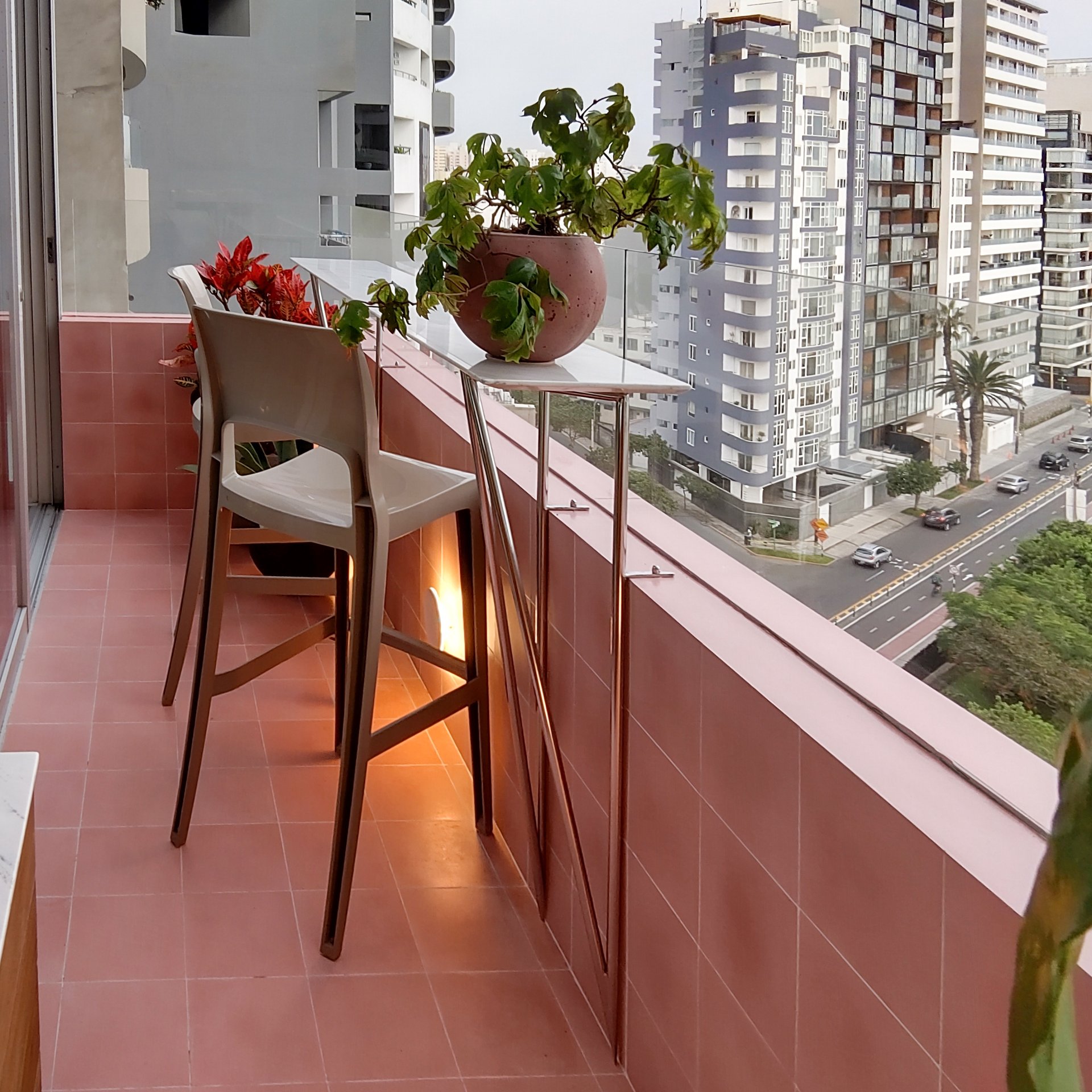 Un balcón con dos sillas y una planta en maceta.