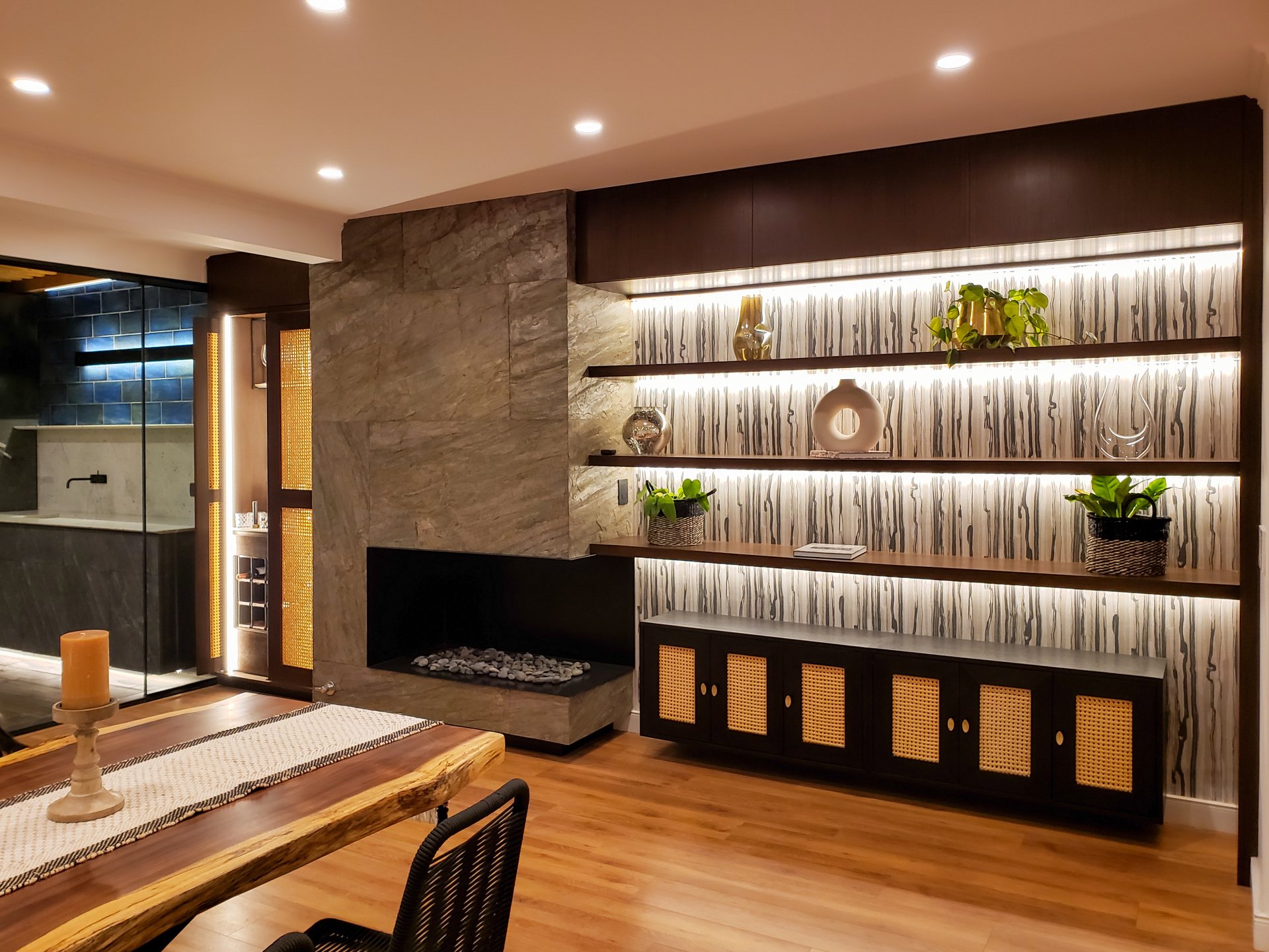 Una sala de estar con chimenea, estanterías, mesa y sillas.