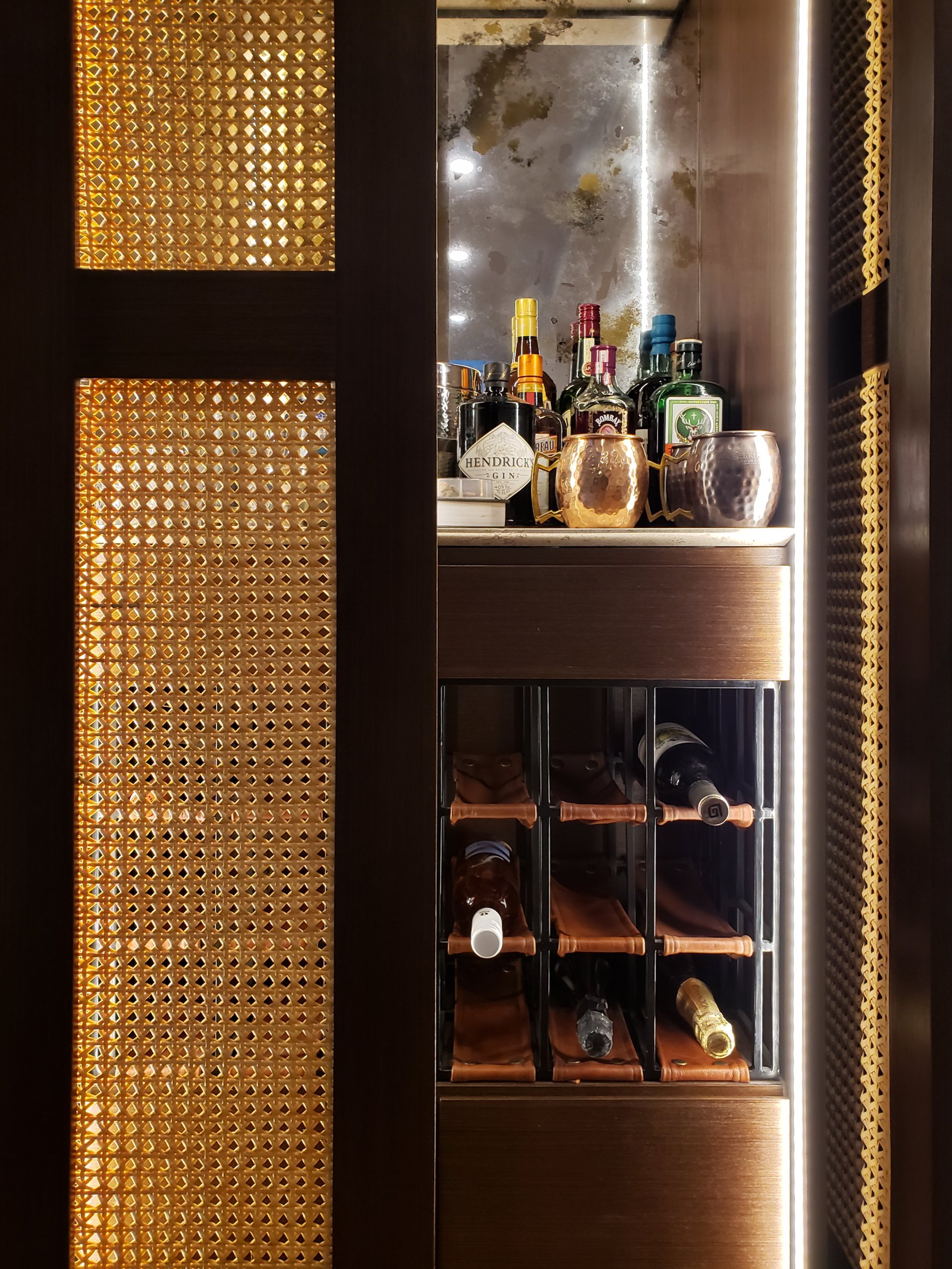 Un estante para vinos con botellas y copas encima.